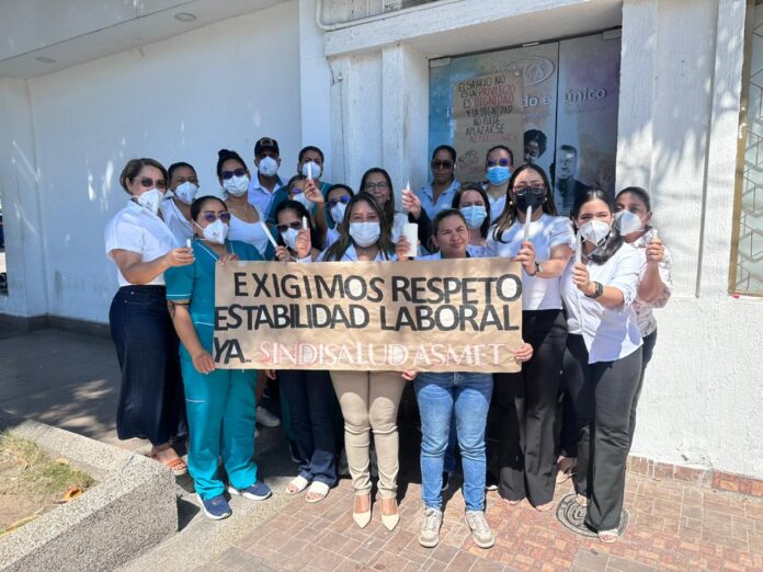 Grupo de trabajadores de Asmet Salud con pancarta en protesta por respeto y estabilidad laboral.