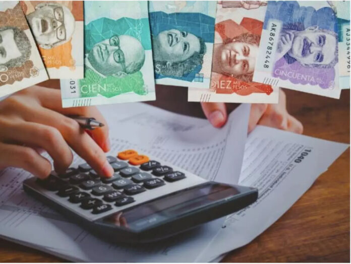 Cálculo de declaración de renta en Valledupar con billetes y calculadora