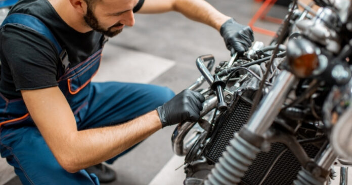 Mecánico realiza revisión y mantenimiento a una motocicleta en taller