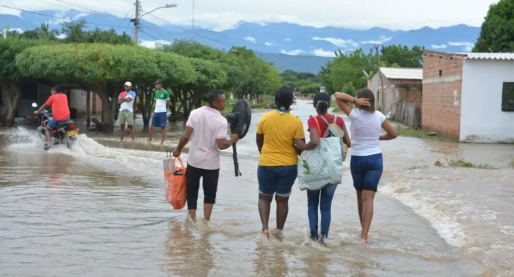 Personas caminan por una calle inundada en medio de la crisis del alcantarillado en Valledupar
