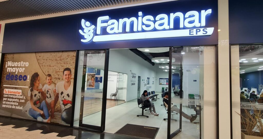 Entrada de Famisanar EPS en Colombia con usuarios en sala de espera recibiendo atención en salud