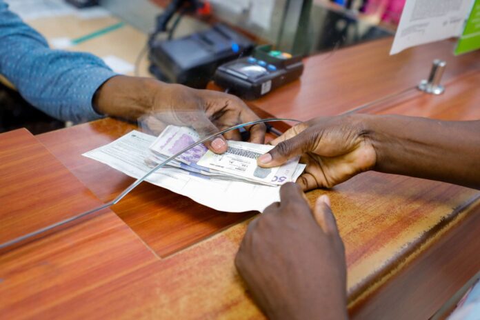 Persona entregando dinero a una mujer madre cabeza de hogar