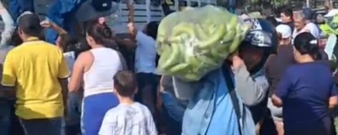 Habitante de Valledupar cargando plátanos entregados por productor en barrio Villa Haidith