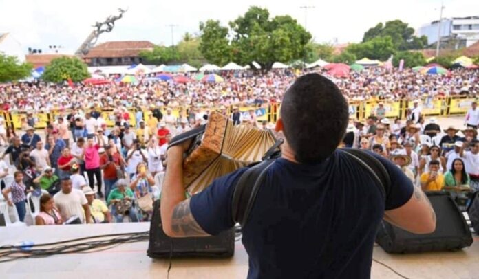 Vista desde atrás de un acordeonero actuando ante una multitud en la Plaza Alfonso López durante el Festival Vallenato.