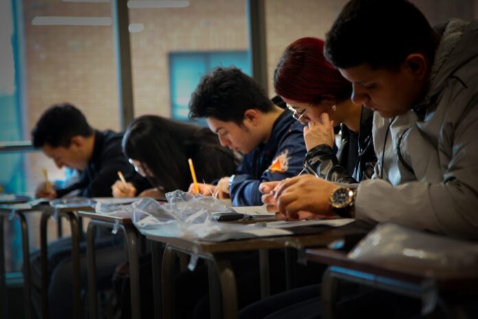 Grupo de estudiantes de educación superior concentrados en un salón de clases en Valledupar, resolviendo el cuadernillo de preguntas de las Pruebas Saber Pro y TyT.