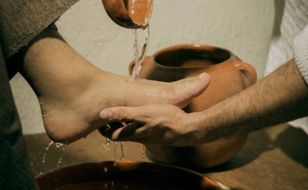 Un sacerdote recrea el lavatorio de pies de Jesús a un fiel durante la misa de la Cena del Señor del Jueves Santo en una iglesia de Valledupar.