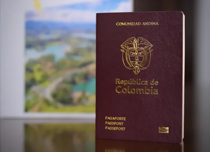 Primer plano del nuevo pasaporte colombiano color vinotinto con el escudo nacional en dorado y símbolo de chip biométrico.