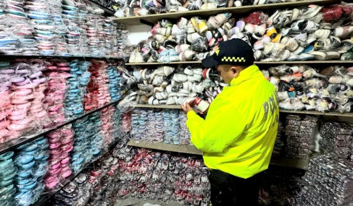 Agente de la POLFA inspeccionando calzado de contrabando en Valledupar durante operativo en bodega del centro.