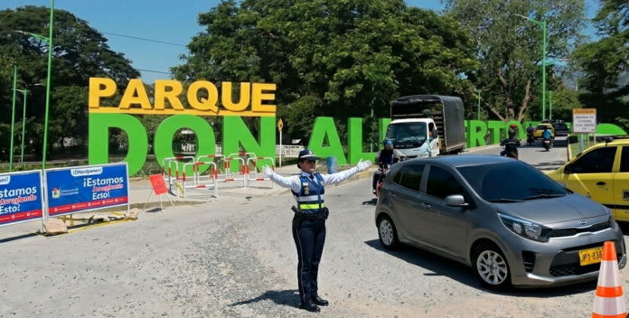 Composición panorámica del Parque Don Alberto y la vía de acceso con un agente de tránsito regulando el tráfico durante las obras.