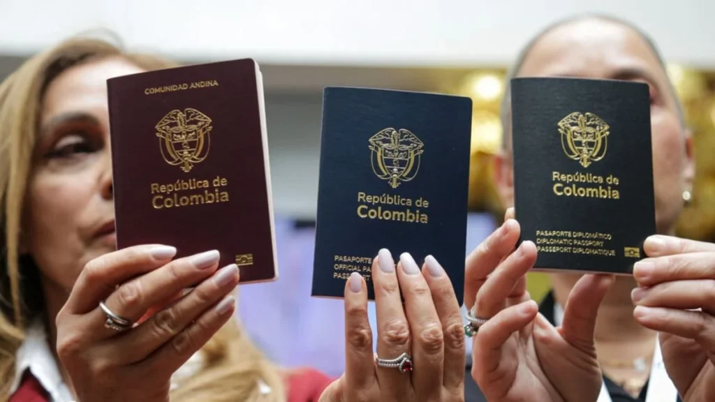 Funcionarias presentan las tres versiones del pasaporte colombiano: ordinario (vinotinto), oficial (azul) y diplomático (negro).