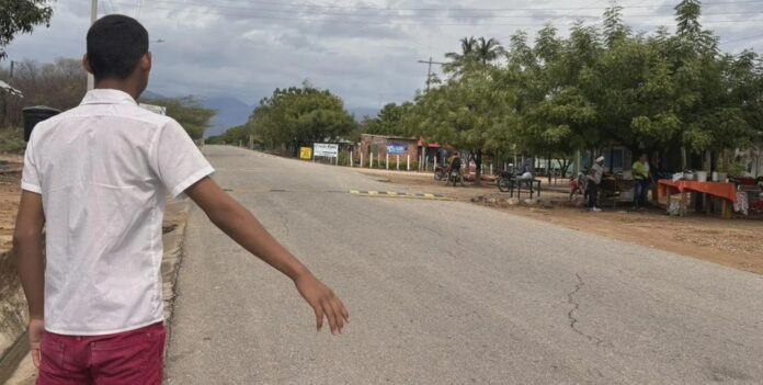 Estudiante esperando transporte escolar en Valledupar en la zona rural de Villa Germania.