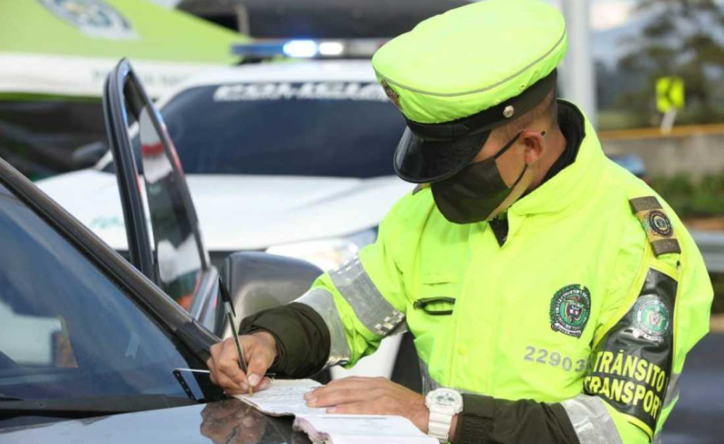 Agente de tránsito verifica documentos de un vehículo durante un operativo de control en vía pública.