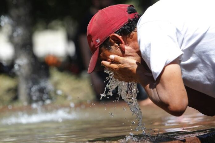 Hombre refrescándose con agua ante las temperaturas extremas de 38 grados en Valledupar por el fenómeno de El Niño.