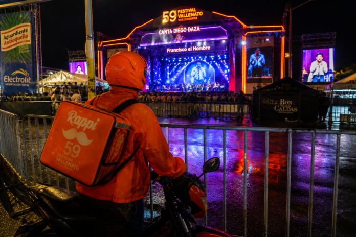 Repartidor de Rappi en su motocicleta observando desde las vallas exteriores el concierto de Diego Daza en el Festival Vallenato 2026.