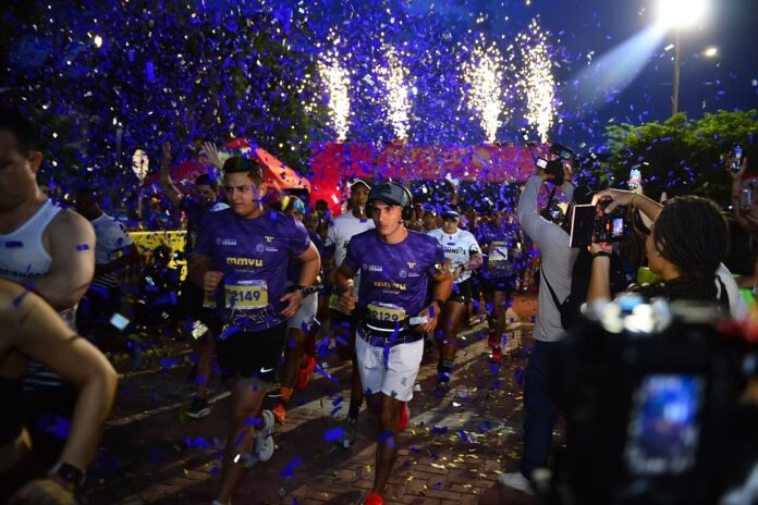 Corredores participando en la Valledupar Night Run 2026 entre fuegos artificiales y luces.