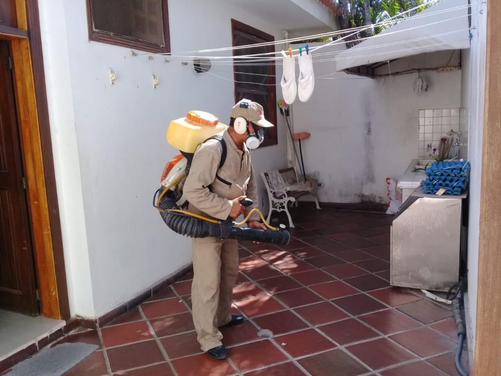 Trabajador de salud realiza fumigación preventiva contra el dengue en una vivienda.