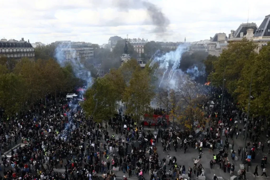 Jack Taylor/Reuters  
Vista general de la plaza de la República, donde se observa a manifestantes caminando entre gases lacrimógenos durante una protesta en París, el sábado 17 de octubre de 2026.
